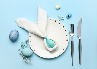 Stylish Easter table setting on blue background