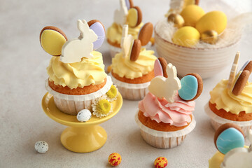 Tasty Easter cupcakes and eggs on light background, closeup