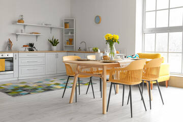 Dining table with setting served for International Women's Day celebration in light kitchen