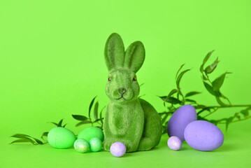 Fototapeta na wymiar Cute Easter bunny and eggs on green background