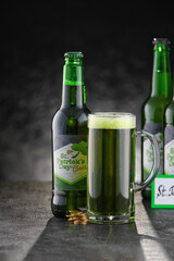Glass and bottles of beer on black background. St. Patrick's Day celebration