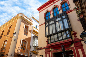 Obraz premium Typical Andalusian color and architecture on residential buildings in the Barrio Santa Cruz district of Seville, Spain.