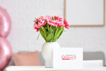 Stylish vase with tulips and greeting card with text HAPPY WOMAN'S DAY on table