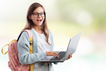 Portrait of smiling teen girl using a laptop computer, studying online