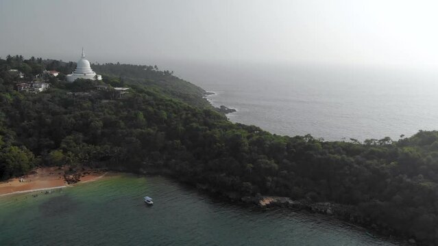 Aerial view of an ocean bay with mountains and Buddhist temple in Sri Lanka