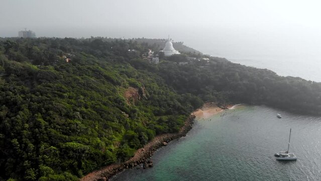Aerial view of an ocean bay with mountains and Buddhist temple in Sri Lanka