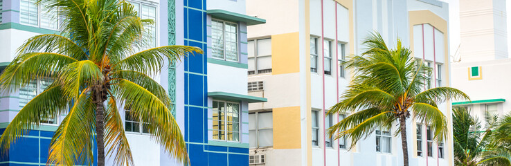 Fototapeta na wymiar Closeup of typical colorful Art Deco architecture with tropical palm tree on Ocean Drive in South Beach, Miami, Florida, USA