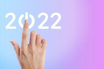 hand presses the start button for 2022. Happy New Year resolution, change, goal, vision,