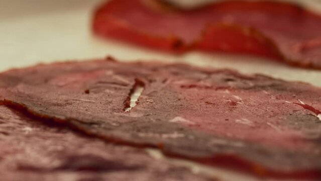 Sliced pastrami being thrown into the pan.Super slow motion 4k Bacon.