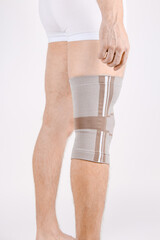 Knee Support Brace on leg isolated on white background. Elastic orthopedic orthosis. Anatomic...