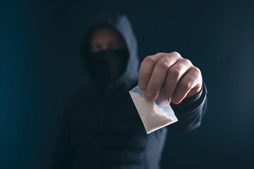 Male silhouette holding packet with drug. Trafficking crime, lifestyle.