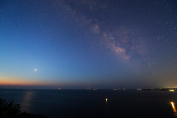伊豆半島の海辺から見る釣舟の灯りと天の川と明けの明星