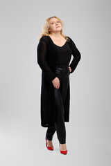 Full body photo of happy old woman in knitted cardigan and faux leather trousers