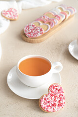 Fototapeta na wymiar a cup of tea with cookies in the shape of a heart on a light background