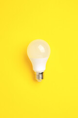 LED lamp on a yellow background. Energy saving concept, alternative energy sources, idea