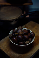 Chestnuts inside a container on a cutting board