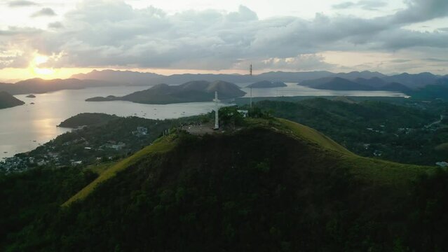 Aerial Of White Cross On Mount Tapyas With Sunset Skies In Distance. Parallax View