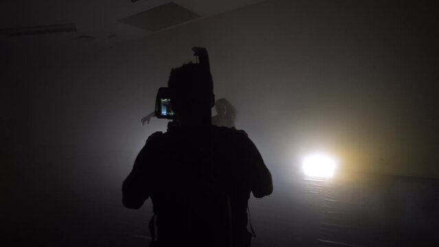 Professional steadicam operator uses a 3-axis camera stabilizer system on a commercial production set. Modern contemporary dancing