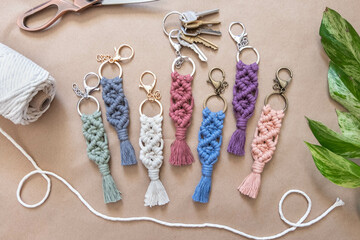 cotton macrame keychains are being displayed on a brown background.