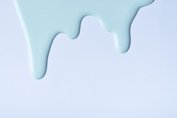Obraz premium Light blue liquid drops of paint color flow down on sky background. Abstract backdrop with turquoise fluid drip