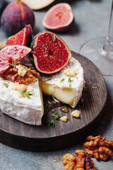 baked camembert cheese with figs, thyme, nuts and honey. close up