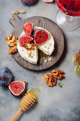 baked camembert cheese with figs, thyme, nuts and honey. glass of red wine
