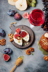 baked camembert cheese with figs, thyme, nuts and honey. glass of red wine