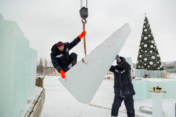 Workers in winter workwear installing ice panels - 486425539