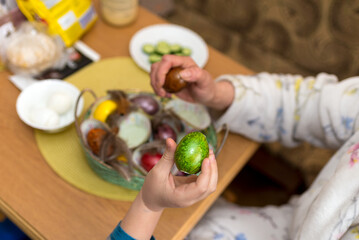 9s boy and his mother having fun with Beating Easter eggs, traditional action in Lithuania for Eastern holiday