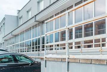 gray exterior aluminum panels facade with windows on industrial factory building.