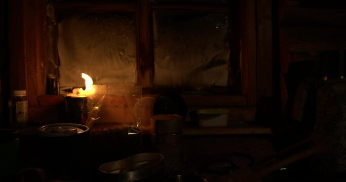 Russian hut, lighting makes a large candle, the window is covered with a snowy pattern, night, warm atmosphere.