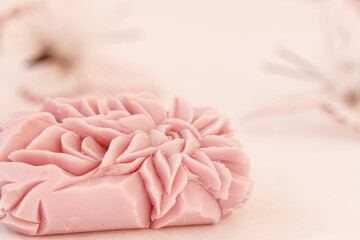 Natural Herbal pink soap carved in beautiful flower in soft pink blurred butterfly background