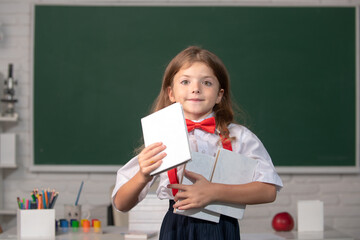 Little school girl student learning in class, study english language at school. Back to school.