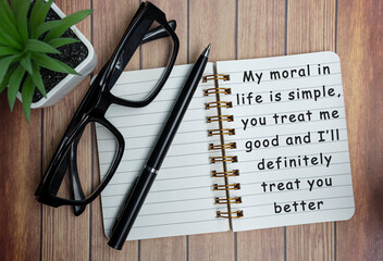 Motivational on a notepad with black reading glass on wooden desk