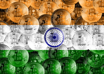 Holds the physical version of Bitcoin and the Indian flag. Conceptual image of cryptocurrency and blockchain technology in India. Double exposure creative bitcoin symbol hologram. 