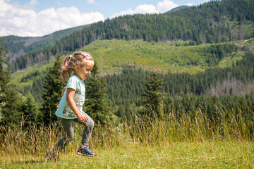 Little girl is relaxing on meadow . Tatra mountains in background. Summer vacation