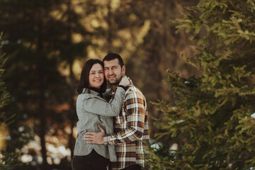 Fototapeta premium Portrait of handsome man hugging his loving wife on a winter day. Selective focus.