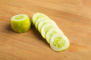 cucumber slices on wooden board.