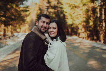 Portrait of handsome man hugging his loving wife on a winter day. Selective focus.