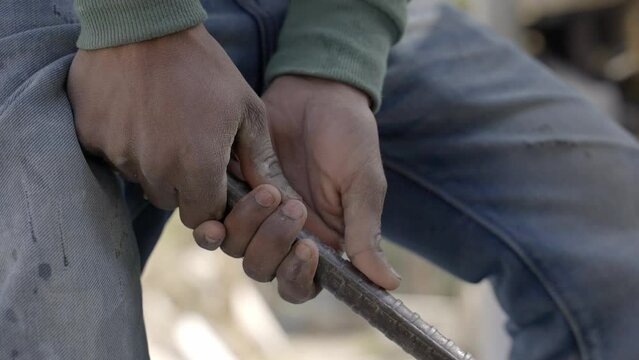 Hardworking Man With Digging Bar Working In A Quarrying Site In India. close up