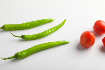 Fresh Green chilli and tomatos on white background.