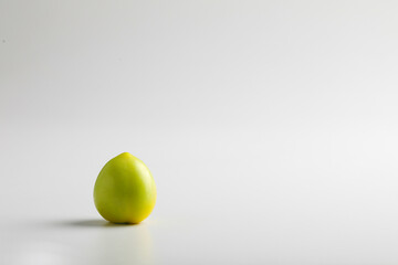 green tomato on white background.