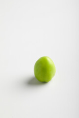 green tomato on white background.