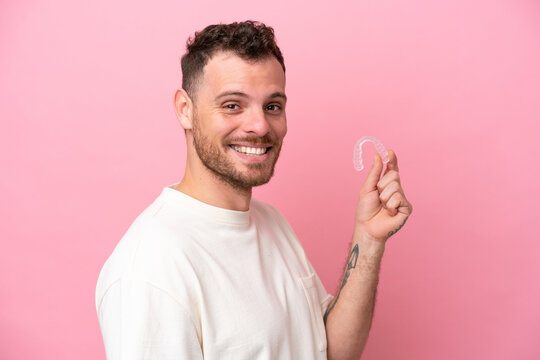 Brazilian man holding invisible braces smiling a lot