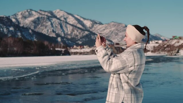 Woman tourist makes photo of nature using smartphone.