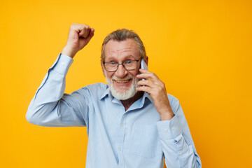 Portrait elderly man gray beard with glasses talking on the phone unaltered