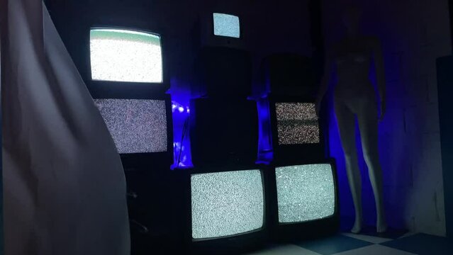 Old Television TV stack with broken white grainy static no signal in blue tiled room with slow motion moving white curtain and flashing strobe light
