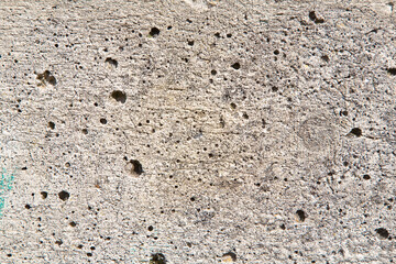 Old concrete wall background with holes left by the evaporation of the mixing water