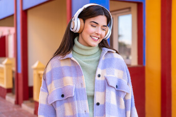Young Brazilian woman at outdoors listening music