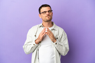 Brazilian man over isolated purple background scheming something